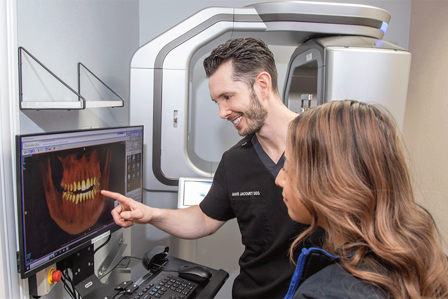 Dr. Jake Jacomet pointing at a computer to discuss a patient's treatment plan